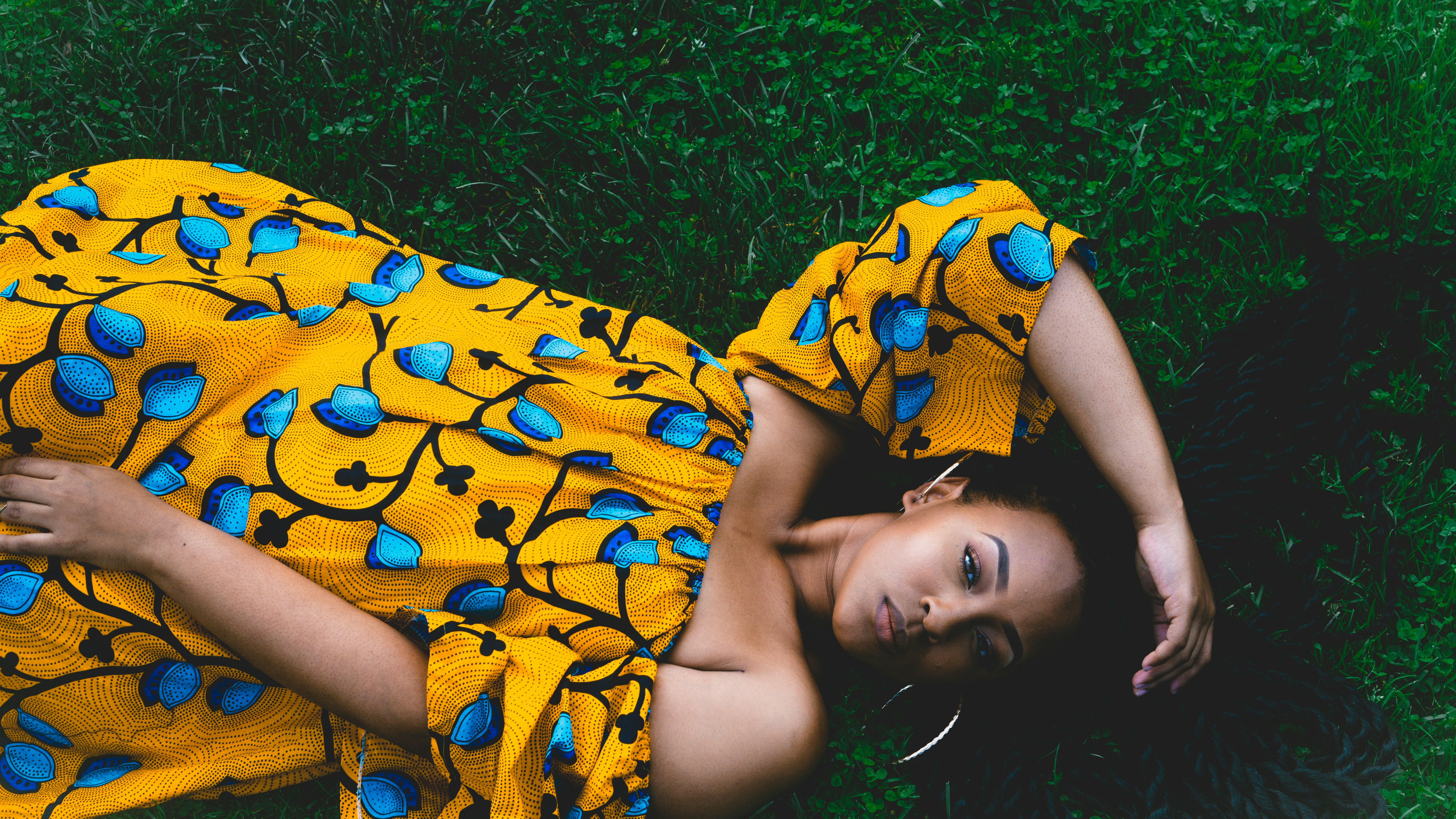 woman laying on green grassland